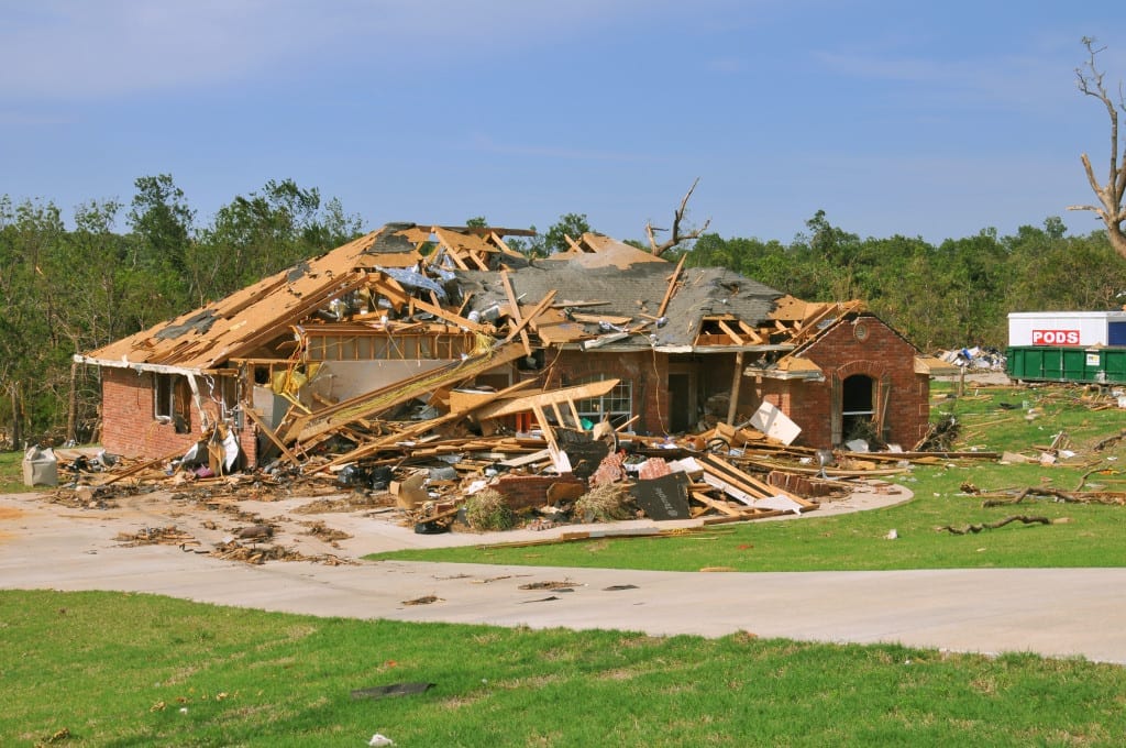 Damaged roof on Oklahoma home showing insurance claim decision